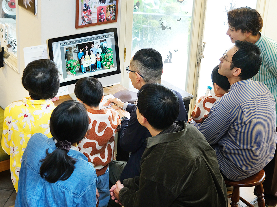 撮影された写真を家族みんなでセレクトしているシーン